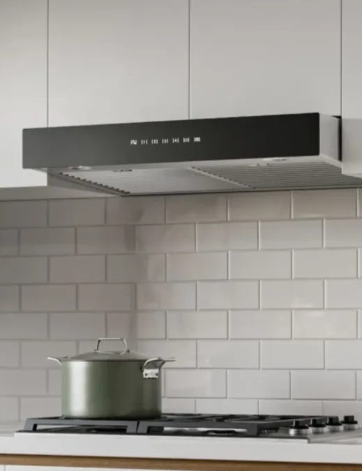 Under-cabinet range hood above a pot on a cooktop